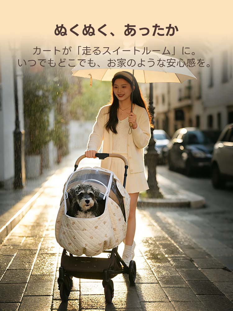  傘を差して雨上がりの街を歩く女性と、くま柄カバーを装着したペットカート。温かい光が差し込む中、愛犬とぬくぬくとした暖かさを共有する幸せな冬の外出シーン。