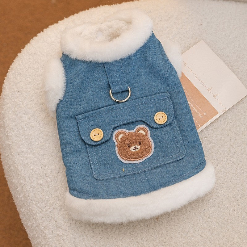もこもこした白いボアの縁取りが映えるブルーのデニムベスト。背面に配されたクマの刺繍と2つの木製ボタン付きポケットが愛らしく、中心には散歩用の頑丈なリード用Dカンを備えた、細部まで質感が伝わる製品の細部画像。