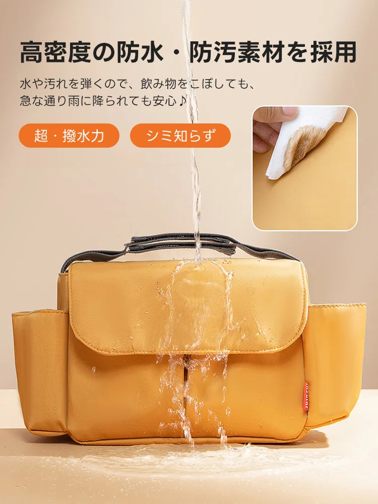  2WAY防水カートバッグの表面で水が玉状に弾かれる様子。マスタード色の高密度生地が水分を強力にガードし、コーヒー等の汚れもサッと拭くだけで綺麗になるシミ知らずの仕様です。急な雨でも中身を安全に保護します。